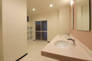 Une salle de bain avec deux lavabos, un miroir et une porte coulissante.