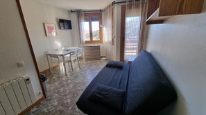 A compact room with a sofa, a small table, and a chair.