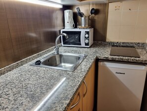A kitchen with a stainless steel sink, a microwave, and a dishwasher.