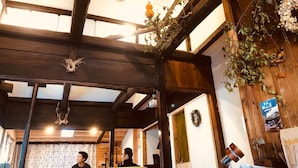 Un intérieur rustique avec des poutres apparentes, un mur en briques et un ventilateur de plafond.