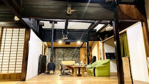 Une pièce de style japonais traditionnel, avec un sol recouvert de tatamis, un plafond bas en bois et une porte coulissante de type shoji.
