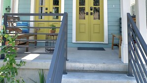 A two-story house with a porch, a staircase, and a number '817' on the front door. - Charming New Orleans Bungalow Steps from French Quarter (New Orleans)