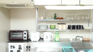 Eine Küche mit Backofen, Kaffeemaschine, Wasserkocher und Spüle.