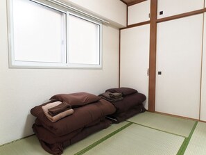 A room with tatami flooring, a sliding door, and a window with blinds. - Heights Syowa 206 (Sapporo)