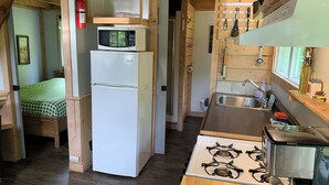 Une cuisine compacte équipée d’un four à micro-ondes, d’un réfrigérateur, d’une cuisinière et d’un évier.