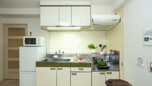 A compact kitchen with white cabinets, a microwave, a sink, and a stove. - Heights Showa 503 (Sapporo)
