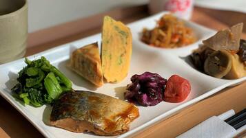 A rectangular white plate with various food items including fish, vegetables, and a piece of tofu.