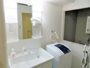 A bathroom with a sink, mirror, and a hairdryer.