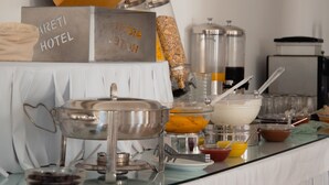 Una mesa de buffet con distintos recipientes de comida y un cartel que dice "AREIT HOTEL".