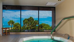 A spa area with a hot tub and a view of the ocean through large windows. - Crescent Beach Club 3B Beachfront Views of the Gulf (Clearwater Beach)