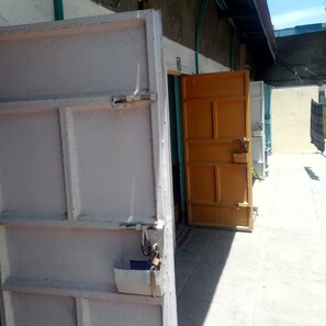 A partially open door with a padlock, a concrete wall, and a glimpse of a tiled floor. - Kasambara Lodge (Naivasha)