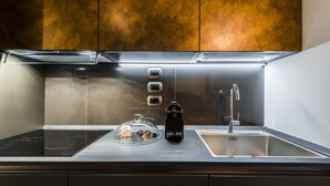 Une cuisine moderne dotée d’un plan de travail en acier inoxydable, d’une machine à café et d’un évier.