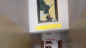 A hallway with a sign reading "LODGINGS" above a reception area. - Kibiro Lodge (Naivasha)
