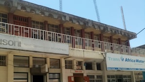 A building with multiple businesses including 'Next Generation Microcredit' and 'Trans Africa Water'. - Kibiro Lodge (Naivasha)