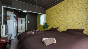A hotel room with a large bed, a desk with a computer, a television, and a bathroom visible through an open door. - PEOPLE NoIII 601 (Sapporo)