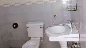 Un baño con inodoro, lavamanos y espejo.