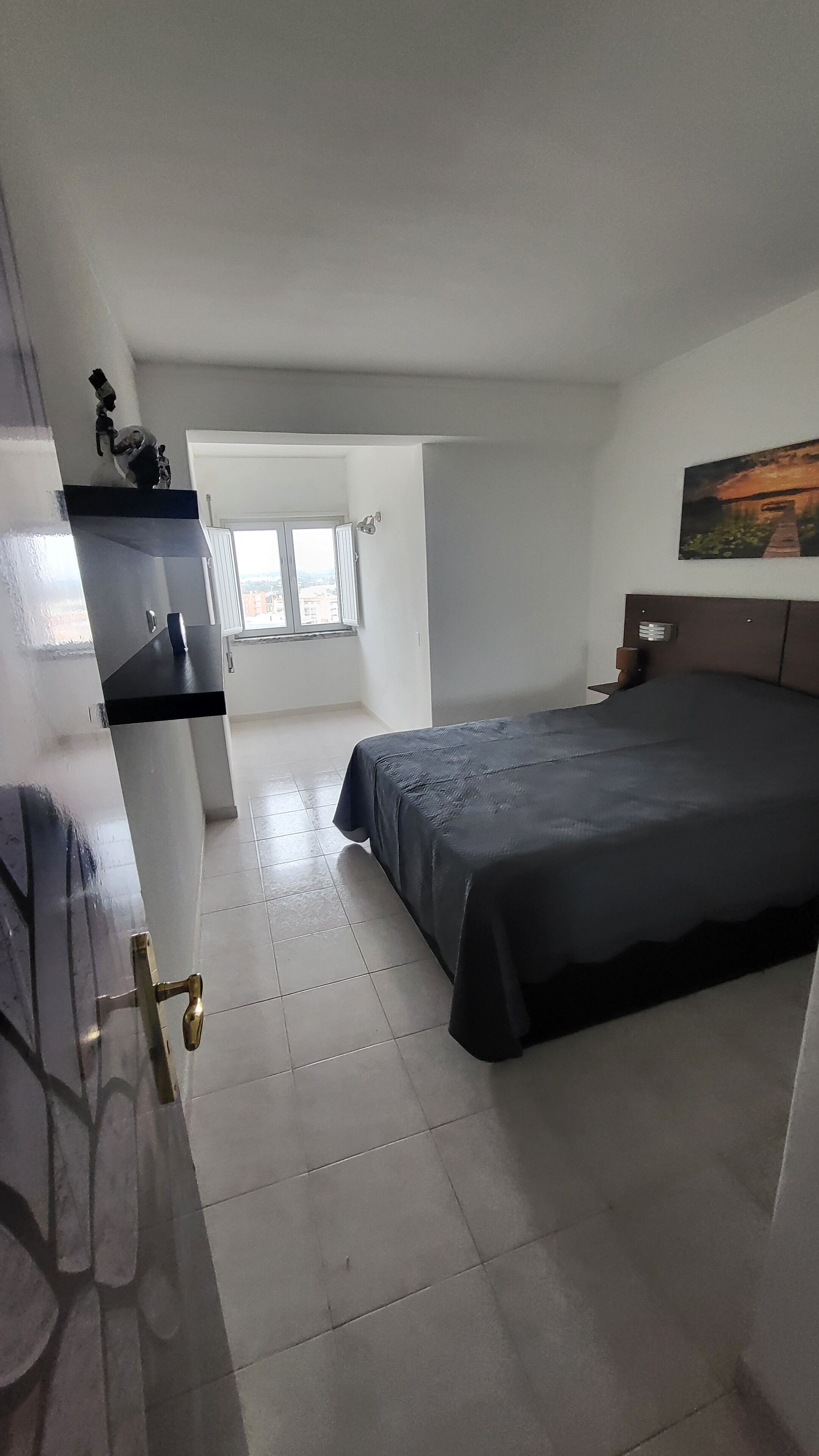 Un dormitorio con cama, escritorio y ventana.