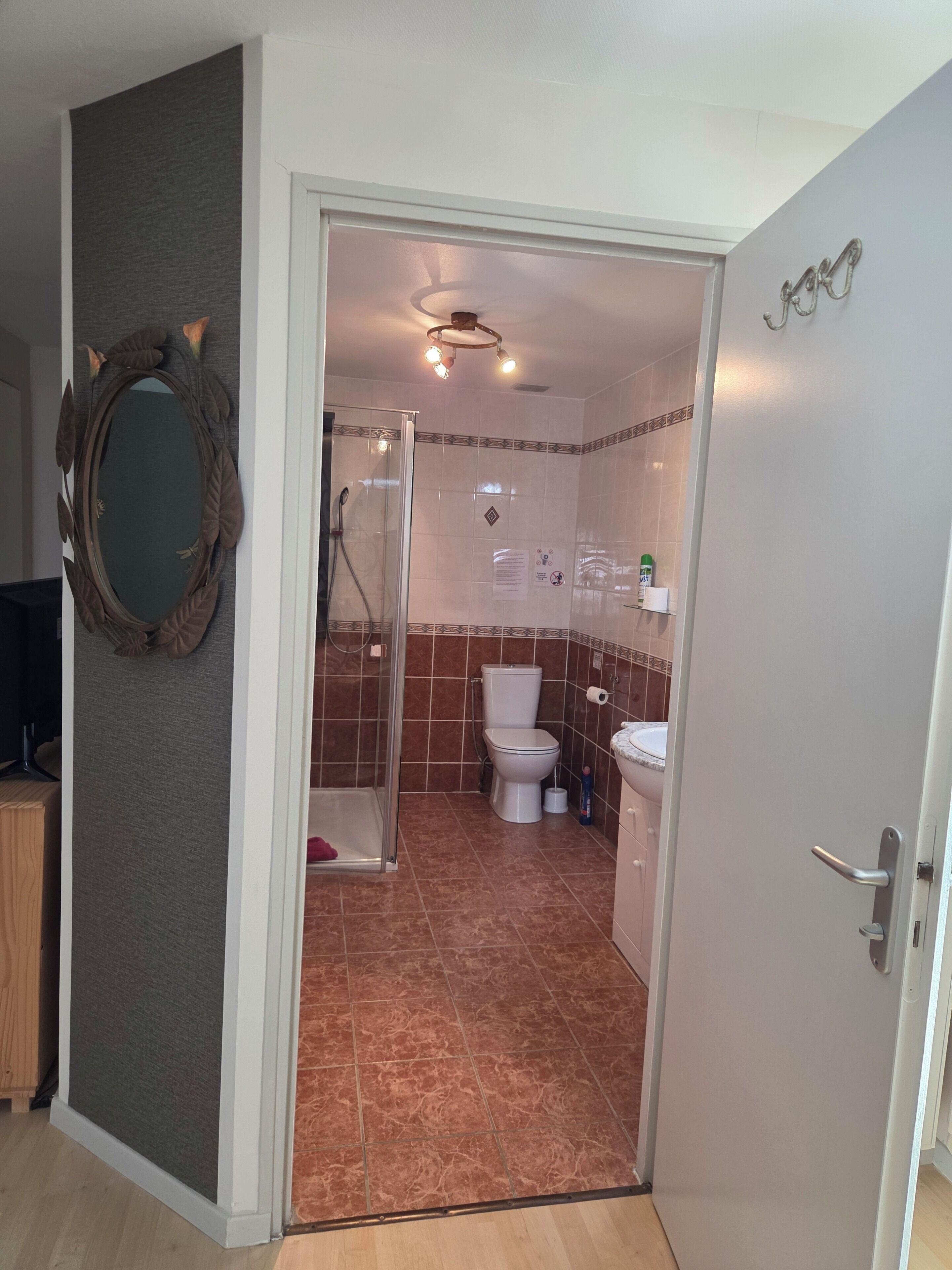 A bathroom with a shower, toilet, and sink.