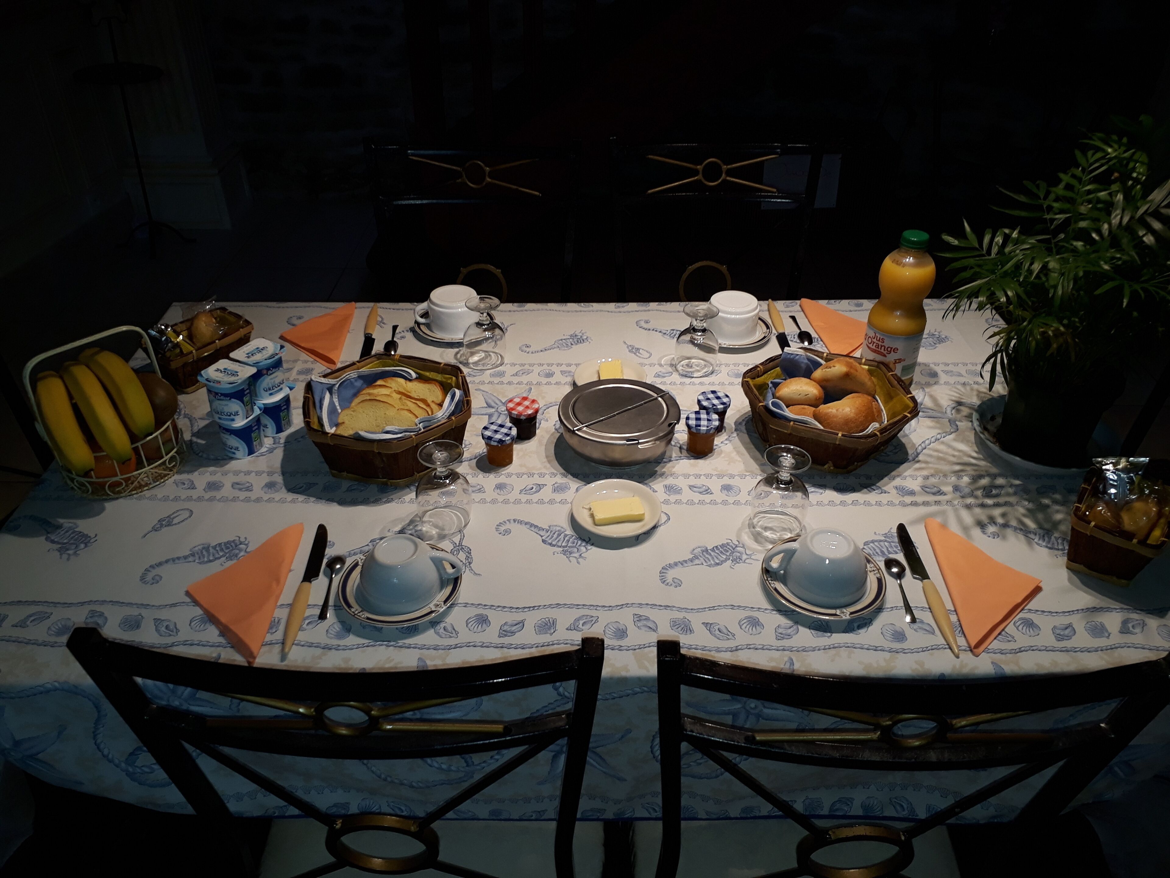 A dining table set with various breakfast items, including bread, butter, and beverages.