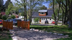 A residential area with a house, parked cars, a wooden fence, and a paved driveway. - Downtown Carbondale Retreat Next to Sopris Park, Walkable & Dog-Friendly (Carbondale)