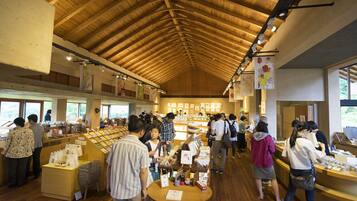 A bookstore with wooden floors and a high ceiling, featuring bookshelves and tables for browsing.