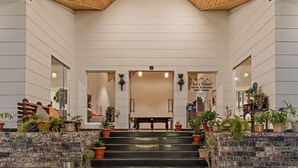Een hotel lobby met een houten plafond, een centrale bank en potplanten.
