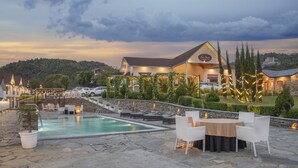 Een hotel met een zwembad, terras en uitzicht op het omliggende landschap.