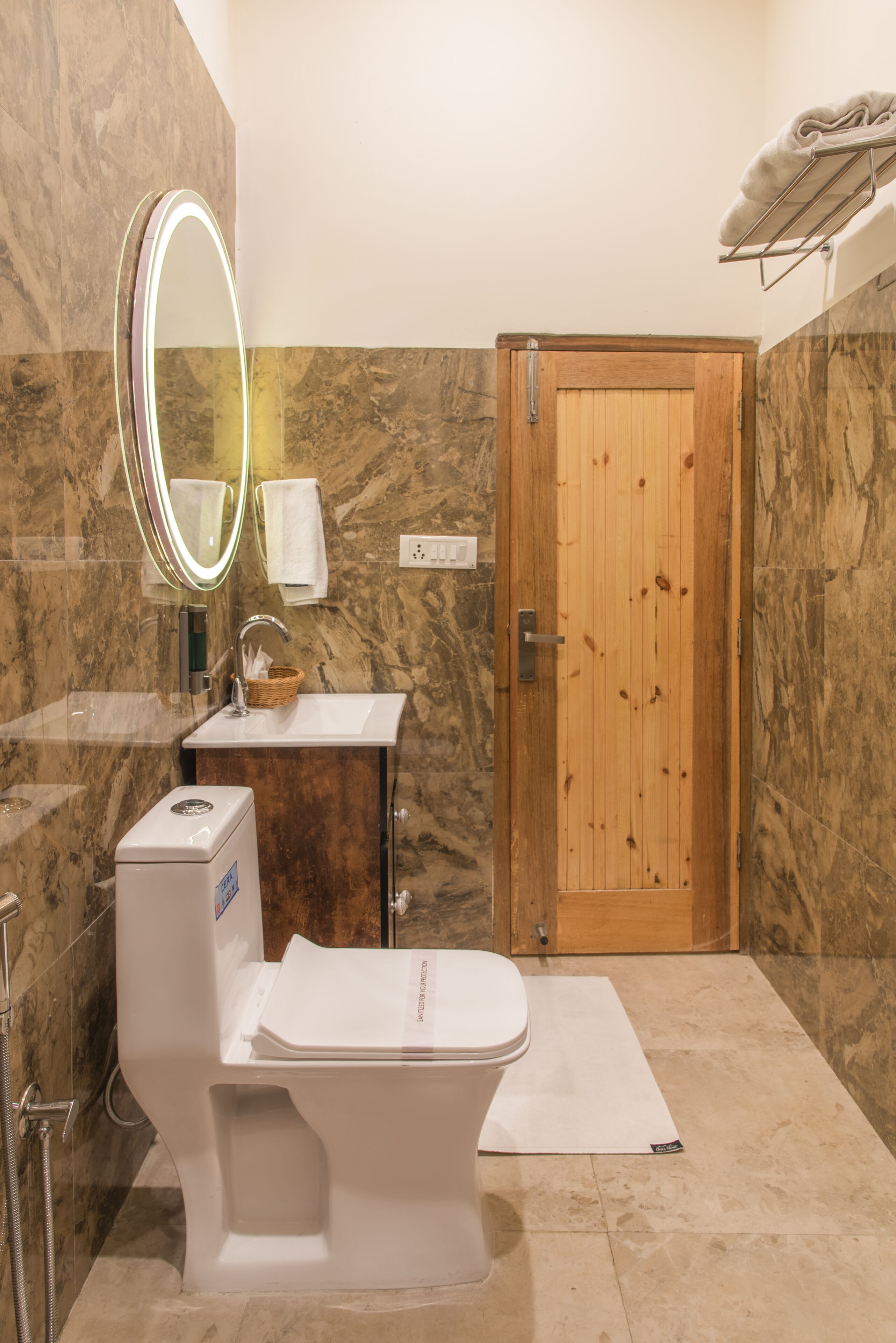 A bathroom with a toilet, sink, and wooden door.