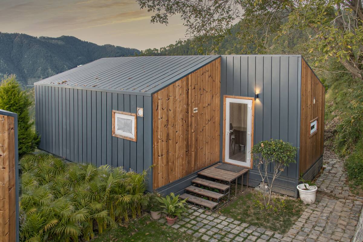 A compact cabin with a wooden exterior, a small porch, and a door leading to the interior.