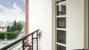 A balcony with a metal railing overlooking a residential street.