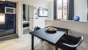 Una cucina moderna con un piano di lavoro nero, una ciotola con oggetti decorativi e un televisore montato a parete.