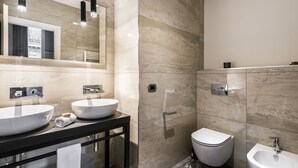 Un bagno moderno con due lavabi, un water e un bidet.