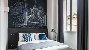 Una camera da letto moderna con un letto grande, un'opera d'arte astratta in bianco e nero, una finestra con tende e un comodino con una lampada.