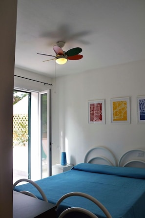 A bedroom with a bed, a ceiling fan, and three framed artworks on the wall. - Pozzo al Moro Village (Campo nell'Elba)