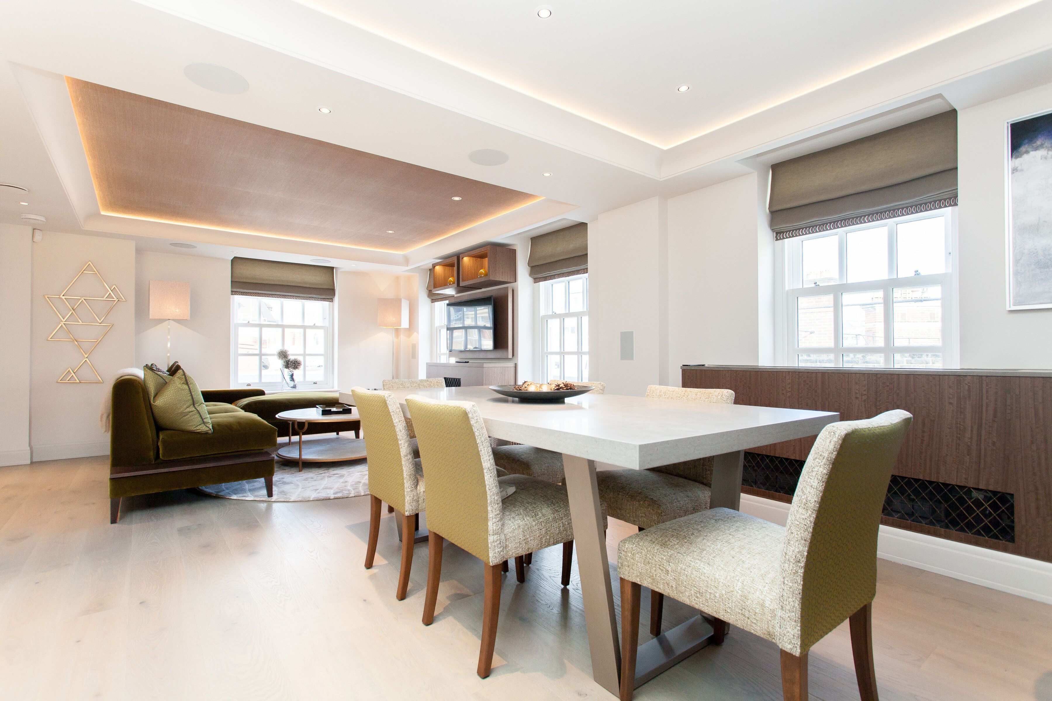 A modern dining area with a large table and chairs, a sofa, and a fireplace.