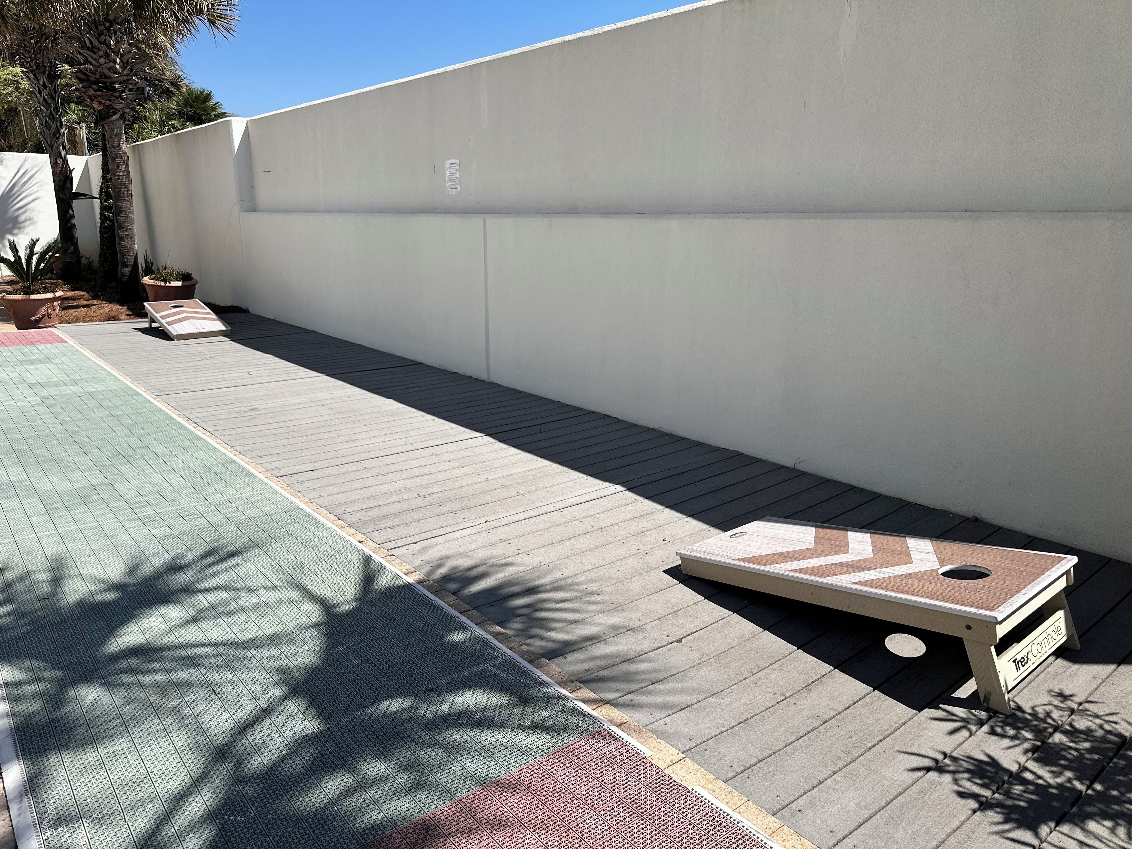 A patio area with a wooden deck, a white wall, and a small table labeled "Tex Connolly".