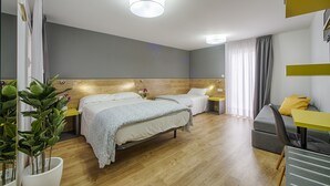 Une chambre d’hôtel moderne avec deux lits, un bureau et un canapé.