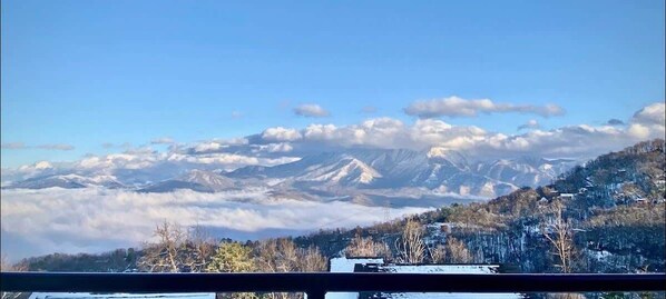 A mountain landscape with snow-covered peaks and a clear sky.