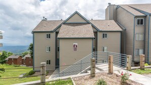 Een meerhoog woongebouw met een garagepoort, een trap en uitzicht op het omliggende landschap.
