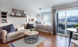 A modern living room with a sofa, coffee table, and a balcony with a view.