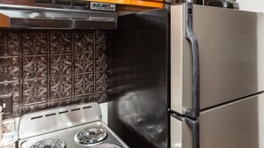Eine Küche mit Herd, Kühlschrank und Holzschränken mit Bär-Motiven.