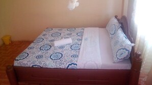 A single bed with a patterned bedspread, a white pillow, and a wooden headboard. - Spanish Restaurant and Lodge Gilgil (Gilgil)
