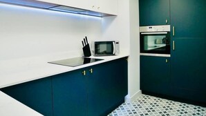 A modern kitchen with white cabinets, a black countertop, a microwave, and a built-in oven. - ❤️❤️❤️❤️❤️Sea View, Walk 2 BEACH, Parking, Netflix (Bournemouth)