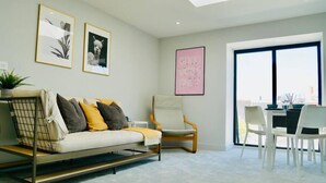 A modern living room with a sofa, armchairs, a dining area, and artwork on the walls. - ❤️❤️❤️❤️❤️Sea View, Walk 2 BEACH, Parking, Netflix (Bournemouth)