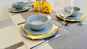 A dining table set with blue bowls, yellow napkins, and wine glasses. - ⭐⭐⭐⭐⭐ Beautiful Apartment Near the BEACH +Netflix (Bournemouth)