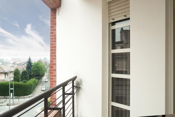 Enjoy the view from this balcony overlooking a quiet residential street.