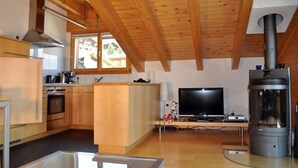 Una cocina moderna con armarios de madera, horno empotrado y un amplio ventanal.