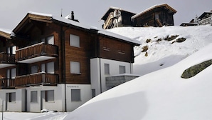 Un edificio in legno a più piani con balconi, immerso nella neve.