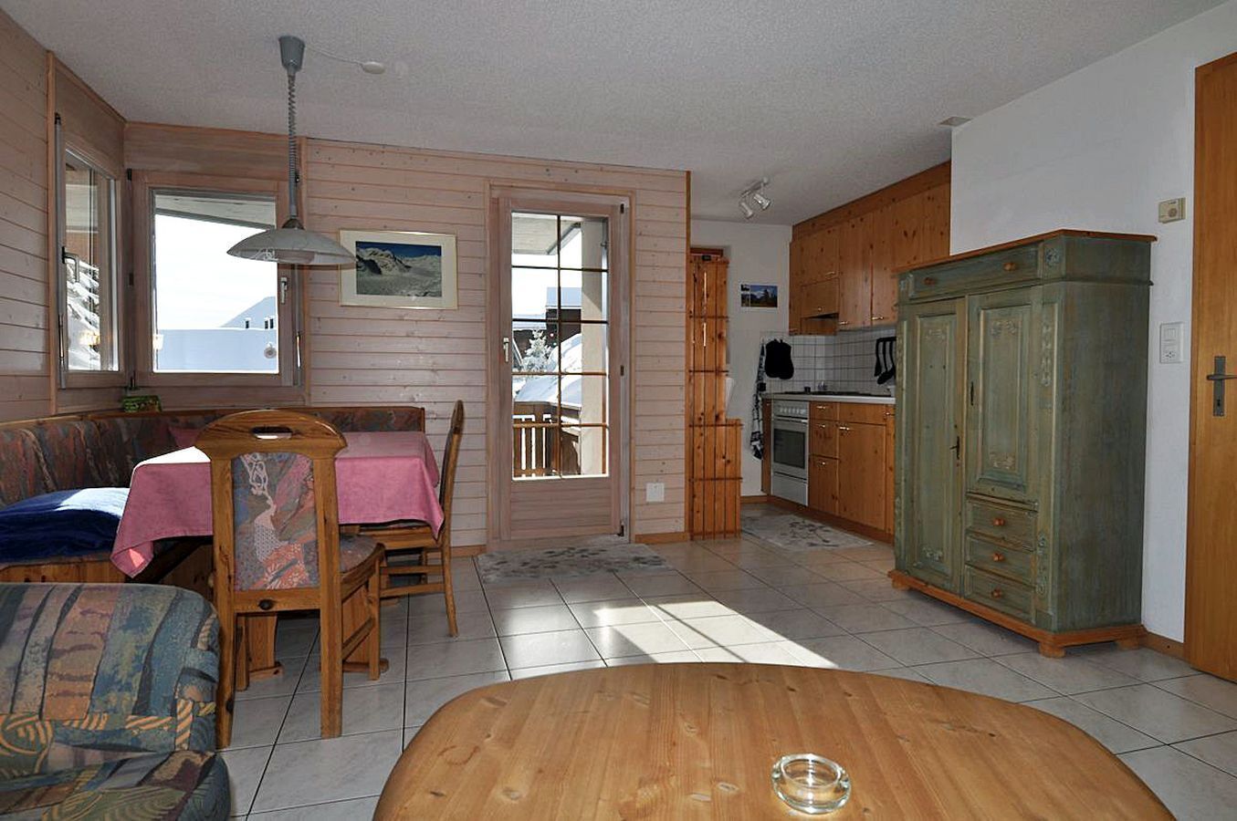 L’intérieur chaleureux d’un chalet comprend un coin repas, une table en bois et une cuisine avec des placards en bois.