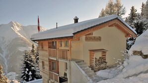 A chalet named 'Bettermloge' with a wooden exterior, a balcony, and a staircase leading to the entrance. - Bettmerlodge (Bettmeralp)